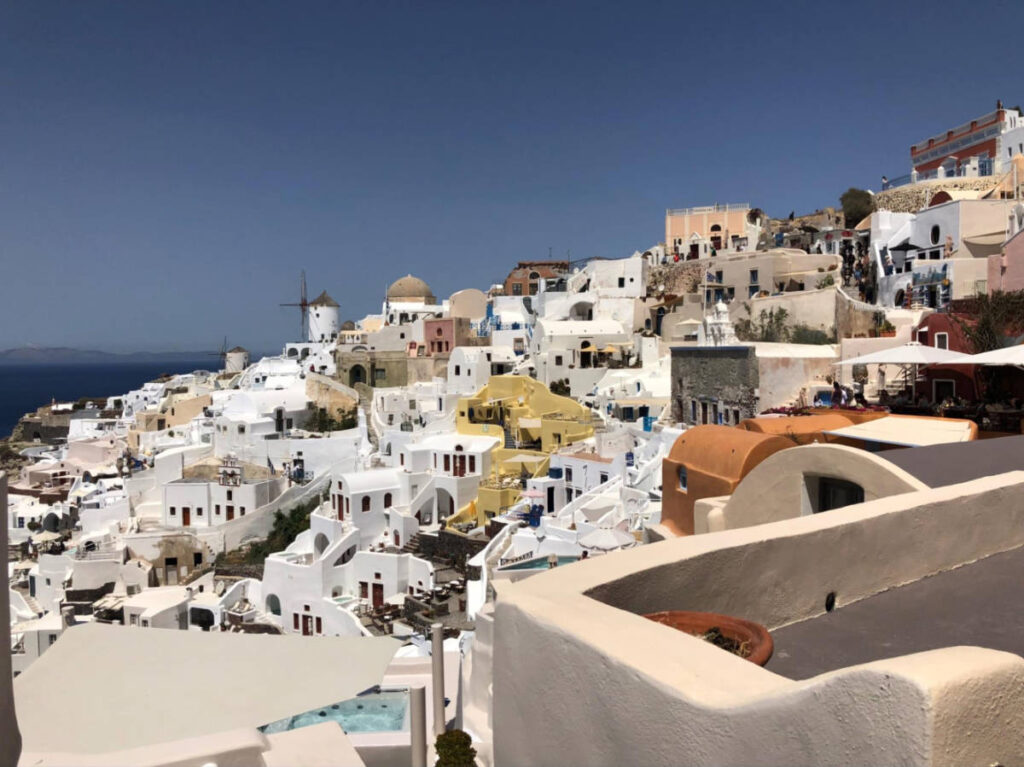 Overlooking view of the beige and whitewashed cave houses in Oia