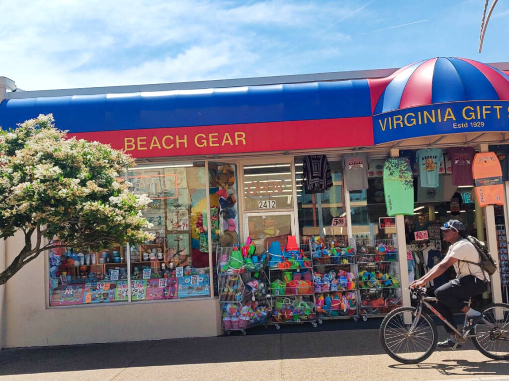 A man cycling in front of the Virginia gift shop