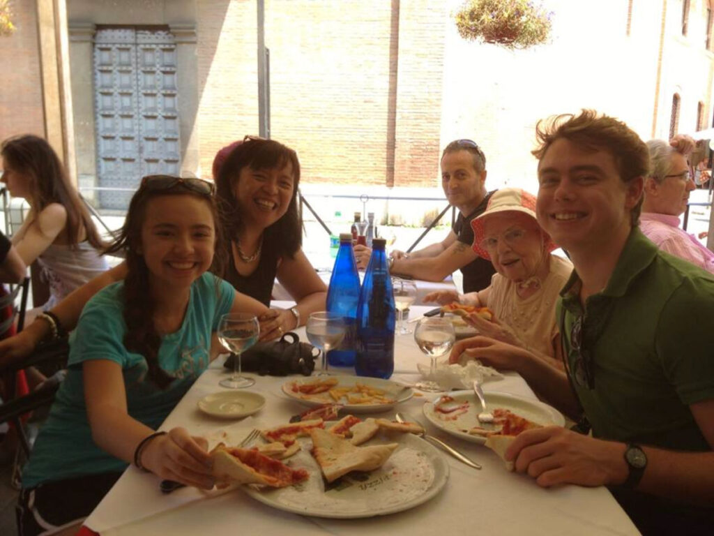 Author Lea Rose Allbaugh and family with Erik dining in Italy