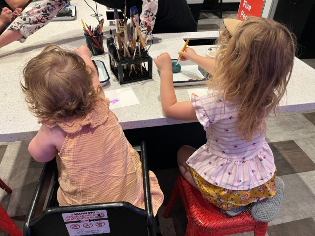 The authors daughters trying out the watercolor station in the Martin ArtQuest