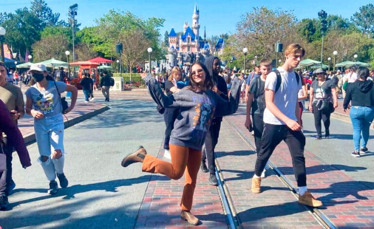 The author McKenna Mobley posing for a photo near the trolley tracks on Main Street in Disneyland