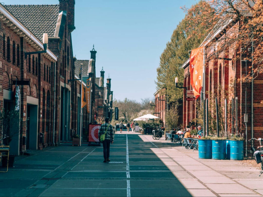 People walking and dining along a street in Westergas