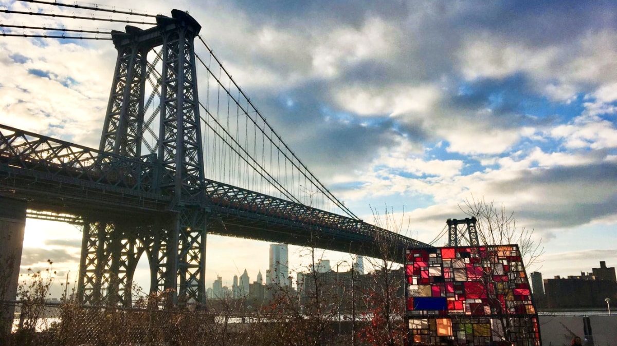 View of the Williamsburg Bridge and Manhattan from Domino Park at sunset