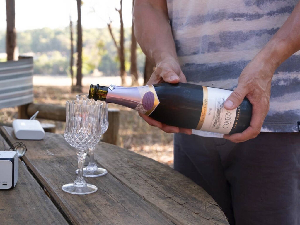 A hand pouring wine on the glass
