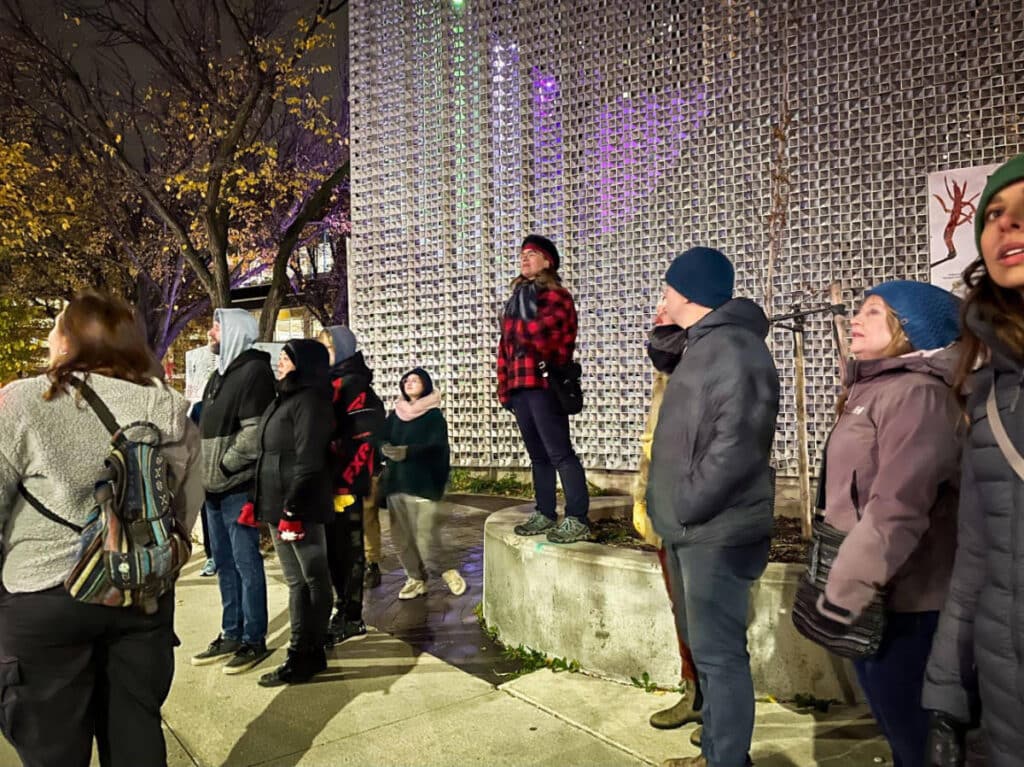 People listening to the tour guide during a Winnipeg ghost walk at the Cube