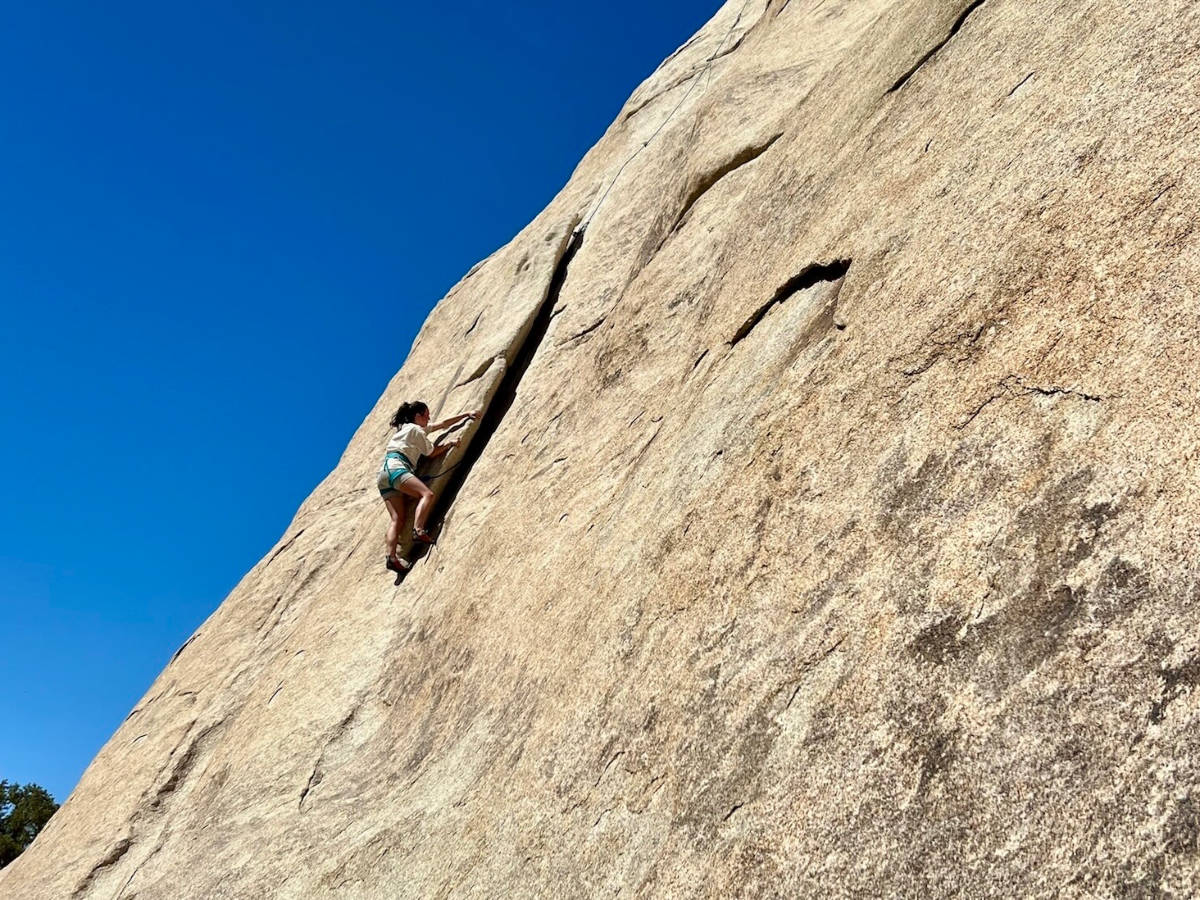 A woman rock climbing in Joshua Tree