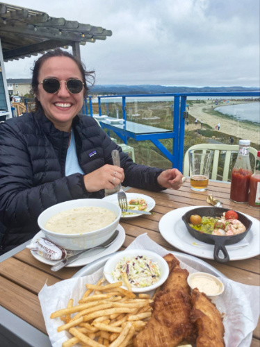 A woman eating fresh seafood with an overlooking view of the ocean in Half Moon Bay