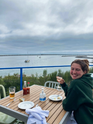 Thea author Laura McFarland, posing for a photo while holding a glass of wine