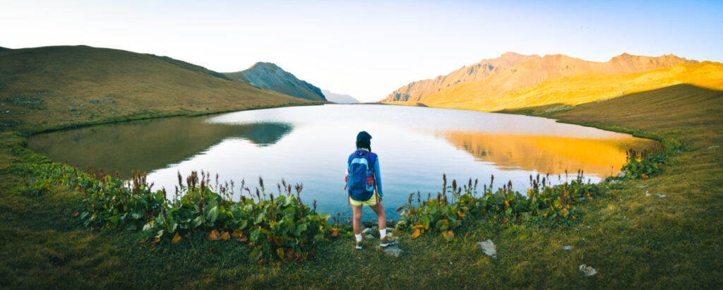 Picturesque panoramic view of a woman admiring the Black Rock Lake at sunrise