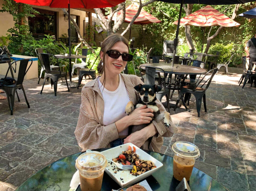 The author's friend holding her dog at the patio of Schmooze