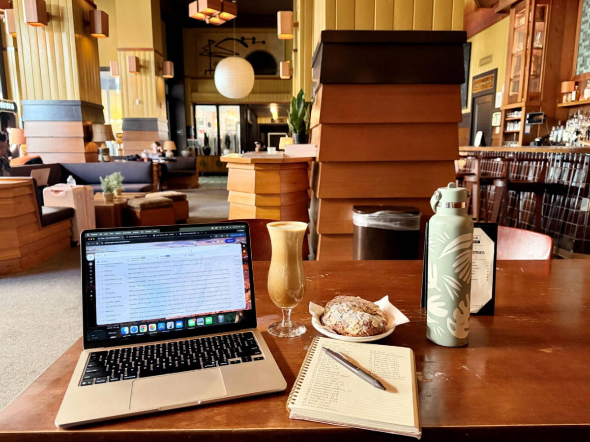 A laptop with coffee and pastry at a coffee shop in the hotel