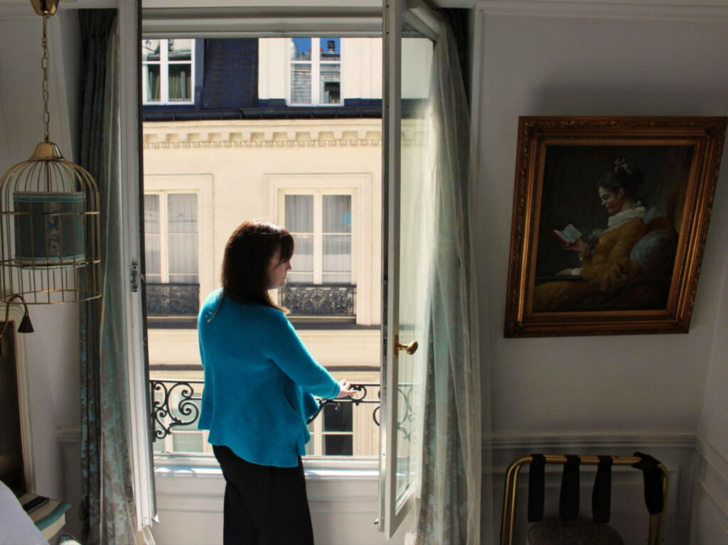 Writer Rachel admiring the view from the open window at the Hôtel Académie Saint-Germain