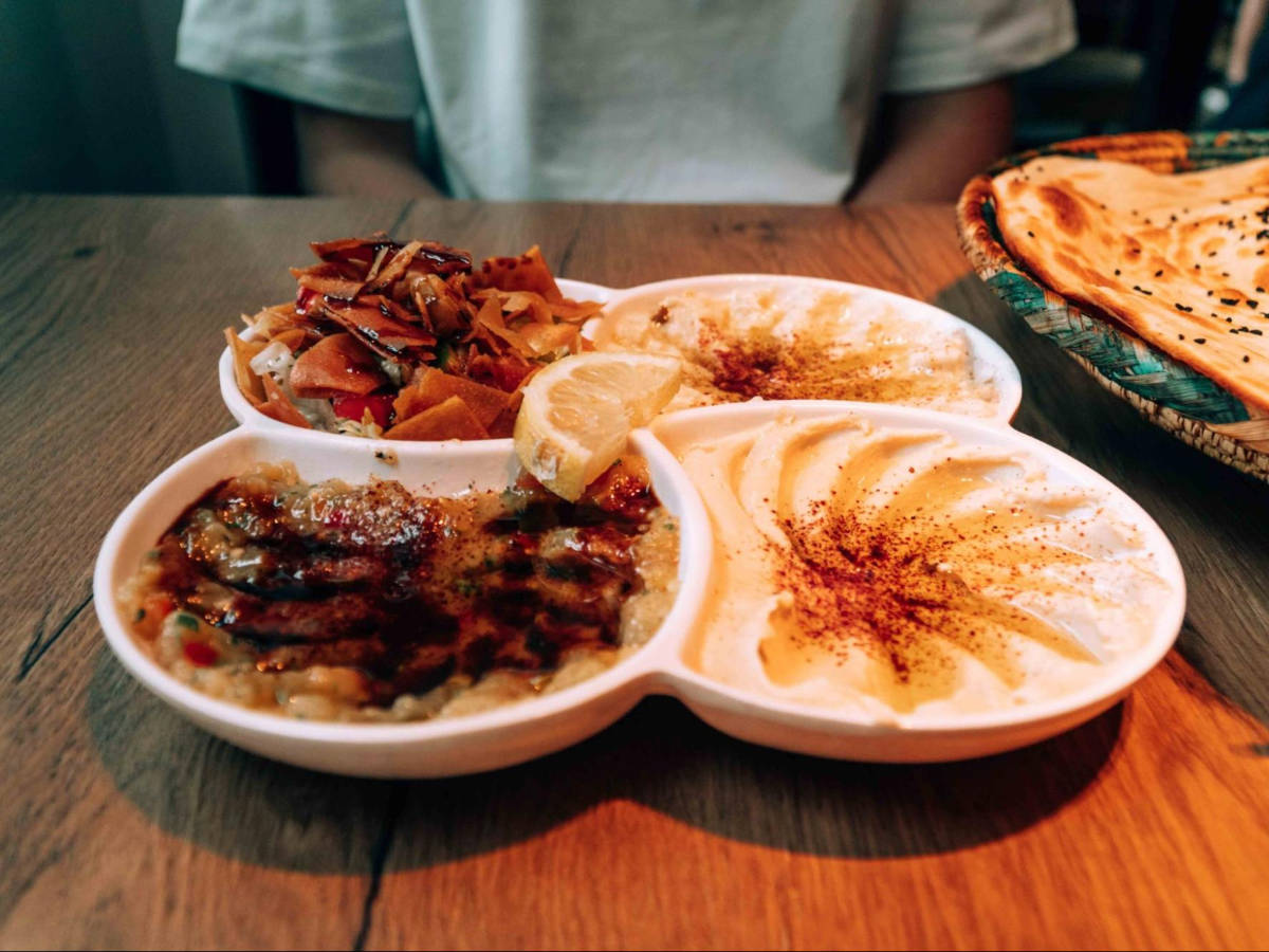 A plate with portions of fattoush, hummus, and baba ganoush at Yemen Restaurant