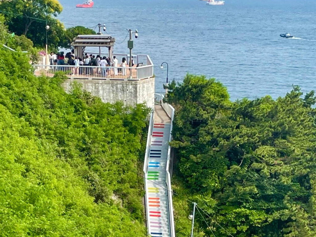 Aerial view of the people at the overlooking deck and the colorful stairway near Huinnyeoul Culture Village
