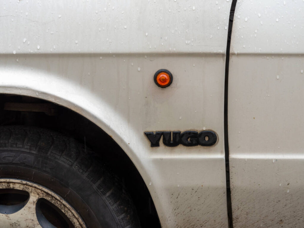 Side detail showing round indicator and logo on a classic Yugo car, made in Yugoslavia